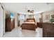 Comfortable bedroom featuring a ceiling fan, tile floors, a TV, and ample closet space at 4408 Rudder Way, New Port Richey, FL 34652