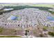 Community aerial view showcasing lakes, houses, streets, and trees under a cloudy sky at 4507 Eternal Prince Dr, Sun City Center, FL 33573