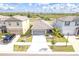 Aerial view of a modern home featuring a well-manicured lawn, two-car garage, and a neatly arranged landscape at 4507 Eternal Prince Dr, Sun City Center, FL 33573