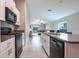 Modern kitchen with stainless steel appliances and granite countertops overlooks the open-concept living area at 4507 Eternal Prince Dr, Sun City Center, FL 33573