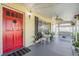 Charming front porch with a swing, chairs, and a red front door, creating an inviting entrance at 4509 S Cortez Ave, Tampa, FL 33611