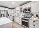 Updated kitchen featuring white cabinetry, stainless steel appliances, and herringbone backsplash at 4509 S Cortez Ave, Tampa, FL 33611
