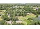 An aerial view captures a property with a barn, ponds, and lush trees in the landscape at 4706 Scott Rd, Lutz, FL 33558