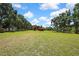 Picturesque barn set in a large, grassy field with mature trees, offering potential for equestrian or agricultural pursuits at 4706 Scott Rd, Lutz, FL 33558