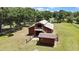 View of red barn featuring metal roof, a staircase, and a fenced yard on a sunny day at 4706 Scott Rd, Lutz, FL 33558