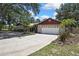 Exterior view of the home featuring a long driveway, stone facade, and lush landscaping at 4706 Scott Rd, Lutz, FL 33558