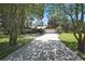 Charming one-story home with a long driveway, stone accents, mature trees, and a well-manicured lawn at 4706 Scott Rd, Lutz, FL 33558