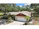 Aerial view of home showcasing a large driveway, two car garage, and lush tropical landscaping at 4706 Scott Rd, Lutz, FL 33558
