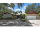 Inviting home exterior showcasing lush landscaping, a stone accent wall, and a two-car garage at 4706 Scott Rd, Lutz, FL 33558