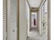 Hallway with white walls, tiled floor and white closet doors, leading to other rooms at 4706 Scott Rd, Lutz, FL 33558