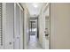 Hallway with tiled floors and shuttered closet doors leads to a view of the pool and backyard at 4706 Scott Rd, Lutz, FL 33558