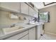 An organized laundry room with a sink, countertop, cabinets, and a window at 4706 Scott Rd, Lutz, FL 33558