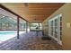 Covered patio with a picnic table and brick flooring faces a screened-in pool and backyard at 4706 Scott Rd, Lutz, FL 33558