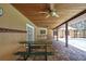 Covered patio with wood ceiling has a bar, picnic tables and brick flooring facing the screened-in pool at 4706 Scott Rd, Lutz, FL 33558