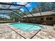 Screened-in pool surrounded by brick flooring has a covered patio and backyard views at 4706 Scott Rd, Lutz, FL 33558