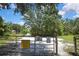Gated entrance offering privacy and security to the property, set amidst lush greenery and clear skies at 4706 Scott Rd, Lutz, FL 33558
