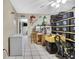 Storage room with tile flooring, stacked black storage containers and cleaning equipment at 4706 Scott Rd, Lutz, FL 33558