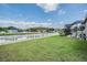 Picturesque backyard featuring a well-maintained lawn, white fence, and tranquil water view at 5049 Rushbrook Rd, Land O Lakes, FL 34638
