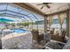 Screened patio with ceiling fan, comfortable seating, and a beautiful view of the pool at 5049 Rushbrook Rd, Land O Lakes, FL 34638
