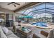 Covered patio featuring wicker furniture, ceiling fan, and view of the pool and fenced yard at 5049 Rushbrook Rd, Land O Lakes, FL 34638