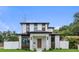 Modern two-story home showcasing a clean white facade with contrasting wood accents and a well-manicured lawn at 5055 2Nd S Ave, St Petersburg, FL 33707