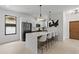 Bright, modern kitchen featuring a quartz island, pendant lighting, black appliances, and sleek white cabinets at 5055 2Nd S Ave, St Petersburg, FL 33707