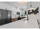 Open concept kitchen with island, white countertops and cabinets, stainless appliances, and modern lighting at 5055 2Nd S Ave, St Petersburg, FL 33707