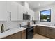 Features modern white cabinets, contrasting brown lower cabinets, and stainless-steel appliances at 5055 2Nd S Ave, St Petersburg, FL 33707
