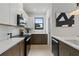 Modern kitchen with stainless steel appliances, white backsplash, and dark lower cabinets at 5055 2Nd S Ave, St Petersburg, FL 33707