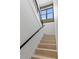 Modern staircase featuring light wood steps, black railing, and ample natural light creating an inviting entrance at 5055 2Nd S Ave, St Petersburg, FL 33707