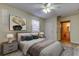 Comfortable bedroom features neutral paint, ceiling fan, updated lamps and an attached bathroom at 5915 Brickleberry Ln # 103, Zephyrhills, FL 33541