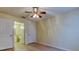 Bedroom with a ceiling fan and ensuite bathroom featuring neutral walls and wood-look floors at 5915 Brickleberry Ln # 103, Zephyrhills, FL 33541
