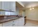 Kitchen with white cabinets, stainless steel dishwasher, and view to dining area at 5915 Brickleberry Ln # 103, Zephyrhills, FL 33541