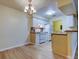 Cozy kitchen with white appliances and cabinets, a tiled backsplash, and a dining area view at 5915 Brickleberry Ln # 103, Zephyrhills, FL 33541