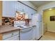 Traditional kitchen featuring white appliances, cabinets and a colorful backsplash design at 5915 Brickleberry Ln # 103, Zephyrhills, FL 33541