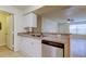 Kitchen features stainless steel dishwasher, laminate flooring, breakfast bar and an open plan at 5915 Brickleberry Ln # 103, Zephyrhills, FL 33541