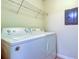 Laundry room features a washer and dryer with a wire shelf for storage above at 5915 Brickleberry Ln # 103, Zephyrhills, FL 33541