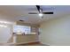 Open-concept living room featuring a ceiling fan, wood-look flooring, and a view of the kitchen at 5915 Brickleberry Ln # 103, Zephyrhills, FL 33541