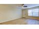Bright living room with a window, ceiling fan, light wood-look flooring and a front door at 5915 Brickleberry Ln # 103, Zephyrhills, FL 33541