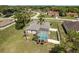 Aerial view showcases a home with a screened pool, lush greenery, and a fenced backyard at 6129 Schalekamp Dr, Spring Hill, FL 34609