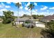 Beautiful backyard with a screened-in pool area, palm trees, and well-maintained landscaping at 6129 Schalekamp Dr, Spring Hill, FL 34609
