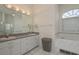 Bright bathroom with double sinks, a large vanity mirror, and a tiled soaking tub at 6129 Schalekamp Dr, Spring Hill, FL 34609