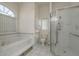 A bright bathroom featuring a glass-enclosed shower and a large soaking tub by a window at 6129 Schalekamp Dr, Spring Hill, FL 34609