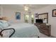 Bright bedroom with a TV, dresser, and a queen bed with light blue bedding and modern decor at 6129 Schalekamp Dr, Spring Hill, FL 34609