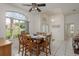 Bright dining area with a ceiling fan, adjacent to a large window that provides natural light and outdoor views at 6129 Schalekamp Dr, Spring Hill, FL 34609