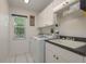 This laundry room is bright, with white cabinets, counter space, a utility sink, and a washer/dryer at 6129 Schalekamp Dr, Spring Hill, FL 34609