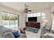 Bright living room featuring tile floors, a ceiling fan, and a view of the pool area, ideal for relaxation and entertainment at 6129 Schalekamp Dr, Spring Hill, FL 34609
