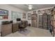 A bright home office featuring a large desk, computer, bookcase, and comfortable desk chair at 6129 Schalekamp Dr, Spring Hill, FL 34609