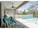 Covered patio with comfortable seating, ceiling fan and view of the screened-in pool at 6129 Schalekamp Dr, Spring Hill, FL 34609