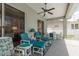 Inviting covered patio with comfortable seating, ceiling fan, and access to the pool and backyard at 6129 Schalekamp Dr, Spring Hill, FL 34609